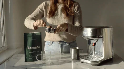 Organic mesquite coffee from Kamana being prepared with an espresso machine on a marble countertop in natural lighting